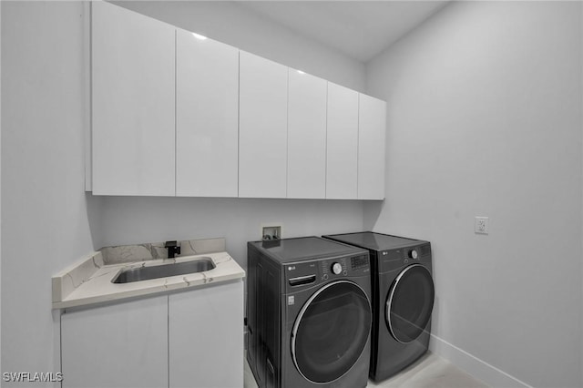 laundry room featuring cabinets, independent washer and dryer, and sink