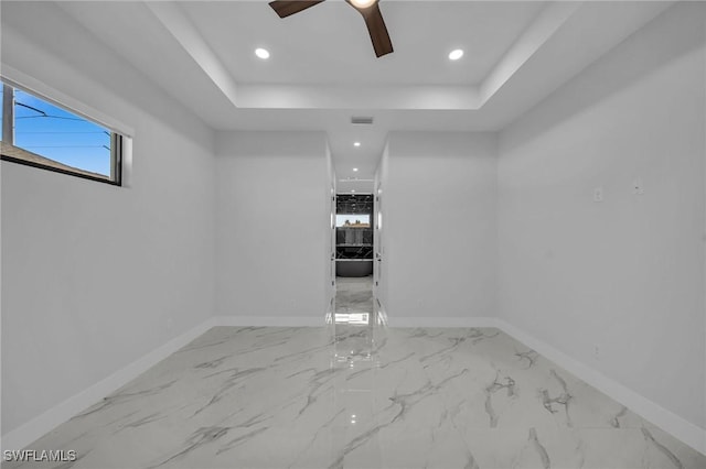 unfurnished room with a tray ceiling and ceiling fan