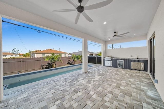 view of pool featuring a patio area, ceiling fan, and exterior kitchen