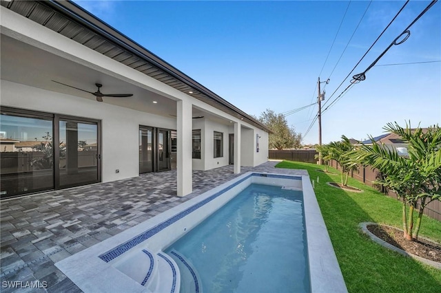 view of pool featuring ceiling fan, a patio area, and a yard