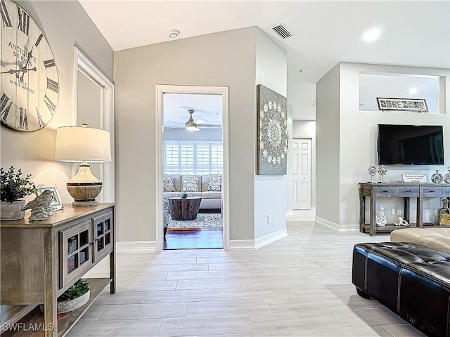 living room featuring light hardwood / wood-style flooring, ceiling fan, and lofted ceiling