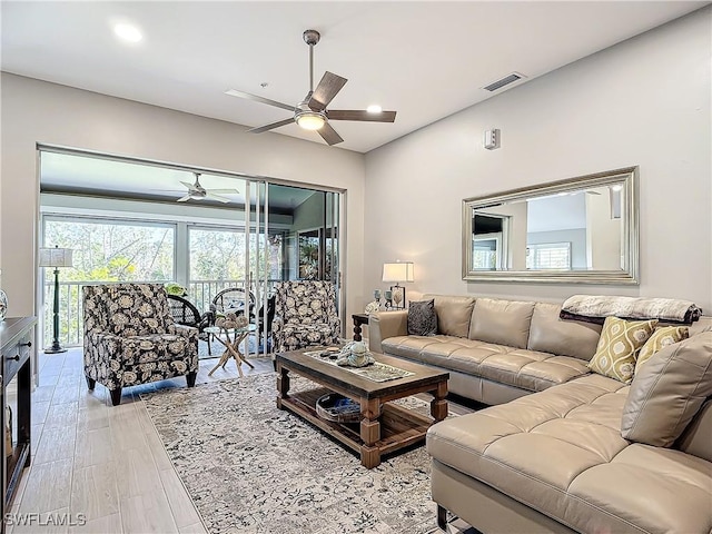 living room with light hardwood / wood-style floors and ceiling fan