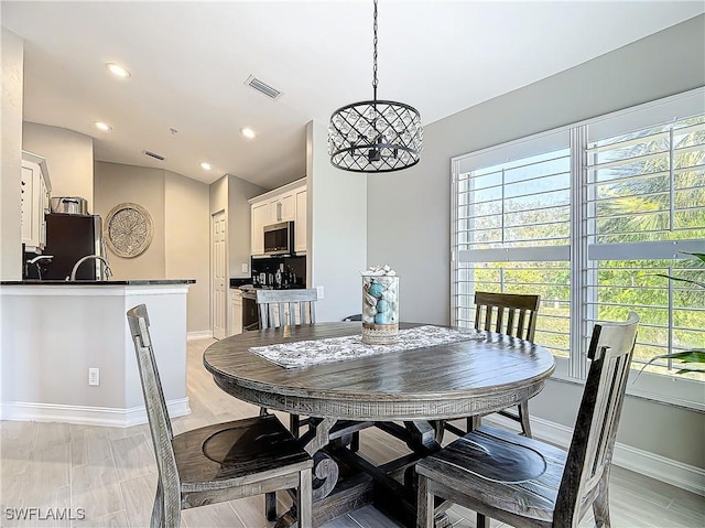 dining space featuring a notable chandelier, light hardwood / wood-style floors, and a wealth of natural light