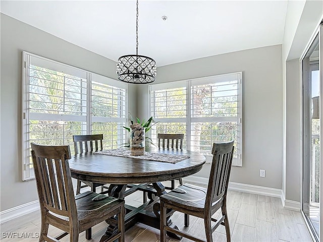 dining area with light hardwood / wood-style flooring and a chandelier