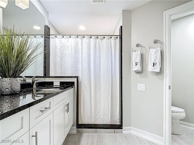 bathroom featuring hardwood / wood-style flooring, vanity, toilet, and a shower with shower curtain