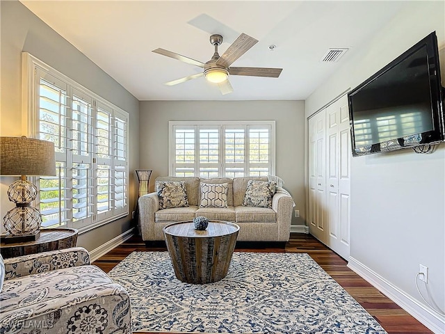 living room with dark hardwood / wood-style floors, a wealth of natural light, and ceiling fan