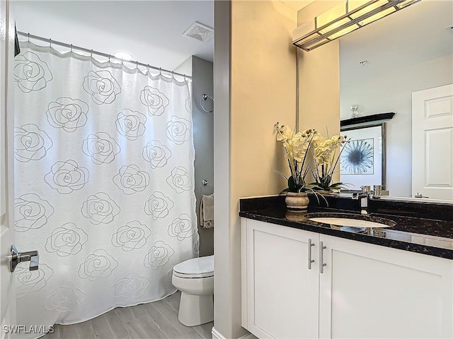 bathroom with hardwood / wood-style floors, vanity, and toilet