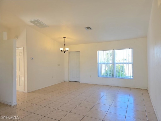 empty room featuring a notable chandelier and light tile patterned flooring