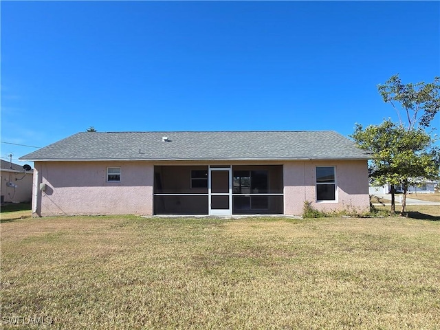 2419 NE 23rd Ave, Cape Coral, FL 33909 - back of property featuring stucco siding, a sunroom, a lawn, and a shingled roof