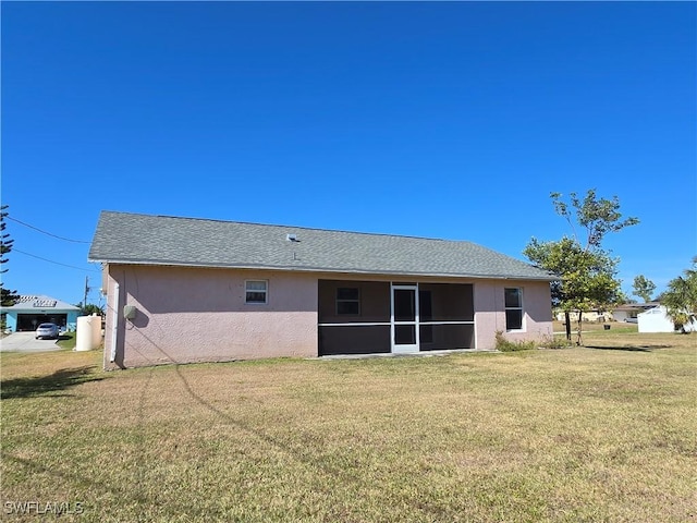 2419 NE 23rd Ave, Cape Coral, FL 33909 - rear view of house with stucco siding, a lawn, and a sunroom