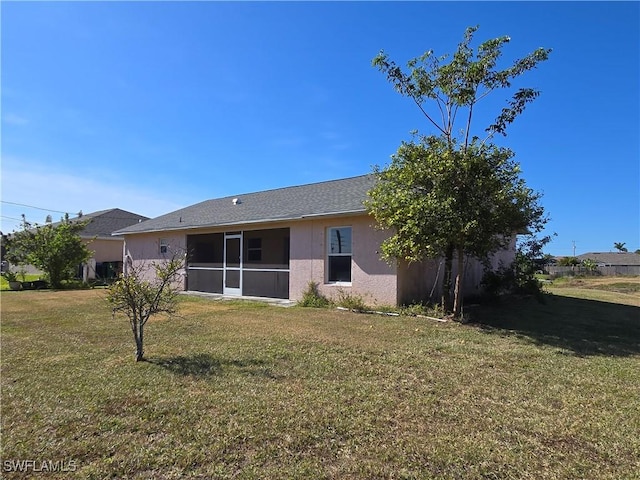 2419 NE 23rd Ave, Cape Coral, FL 33909 - rear view of property featuring a lawn, stucco siding, and a sunroom