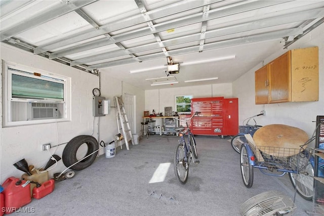 garage with cooling unit, a garage door opener, and electric panel