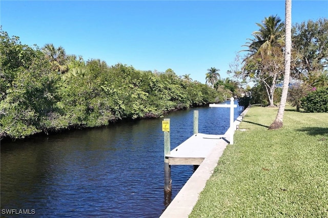 view of dock featuring a lawn and a water view