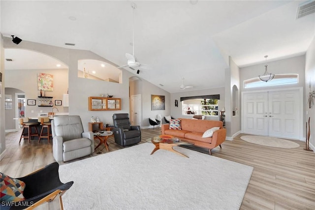 living room with hardwood / wood-style floors, ceiling fan, sink, and high vaulted ceiling