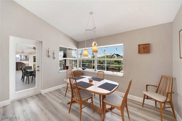 dining room featuring ceiling fan, light hardwood / wood-style floors, and vaulted ceiling