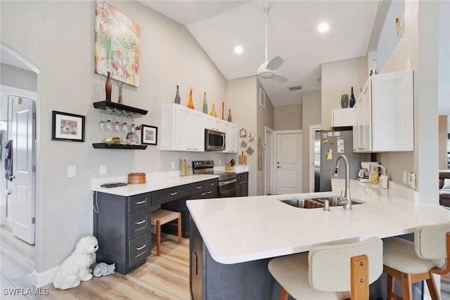 kitchen featuring sink, white cabinets, stainless steel appliances, and vaulted ceiling