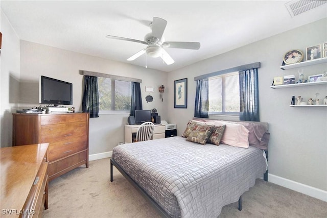 carpeted bedroom featuring multiple windows and ceiling fan