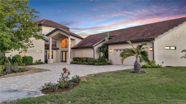 mediterranean / spanish-style house featuring a yard and a garage