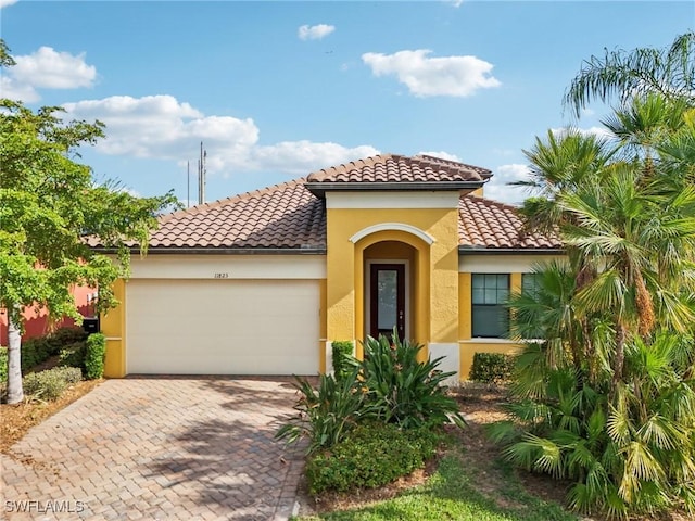11823 Timbermarsh Ct, Fort Myers, FL 33913 - mediterranean / spanish-style house featuring a tiled roof, an attached garage, stucco siding, and decorative driveway