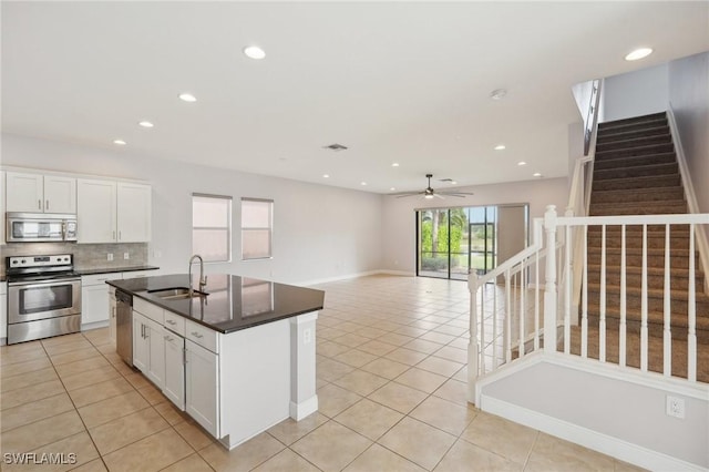 11823 Timbermarsh Ct, Fort Myers, FL 33913 - kitchen with appliances with stainless steel finishes, a sink, dark countertops, light tile patterned floors, and a ceiling fan