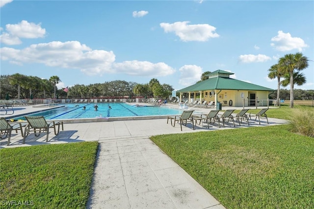 view of swimming pool with a yard and a patio area