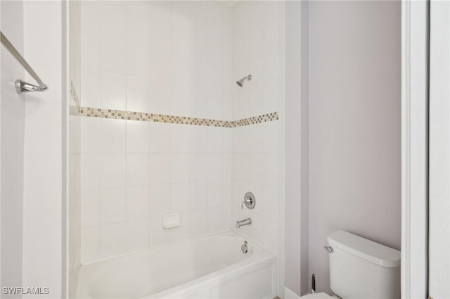 bathroom with toilet and tiled shower / bath combo