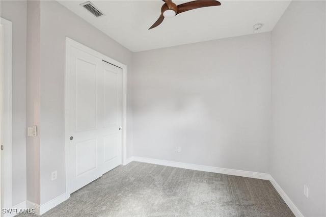 unfurnished bedroom featuring ceiling fan, a closet, and carpet