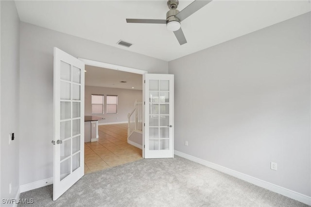 carpeted empty room featuring ceiling fan and french doors