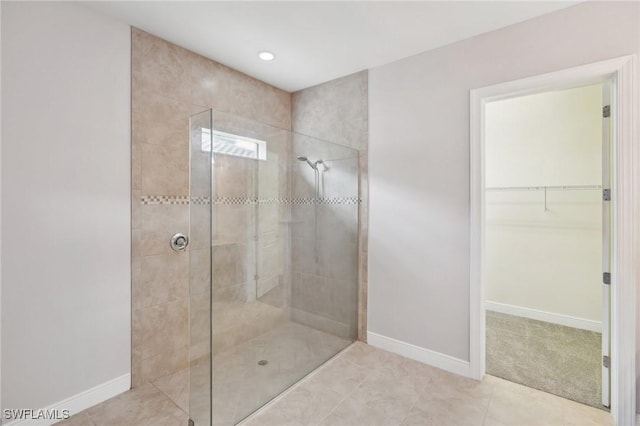 bathroom featuring tile patterned flooring and a tile shower