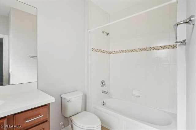 full bathroom featuring vanity, tiled shower / bath combo, and toilet