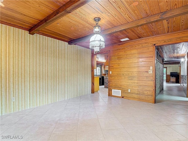 tiled spare room featuring beam ceiling, wooden ceiling, and wood walls