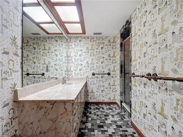 bathroom with vanity and a shower with shower door