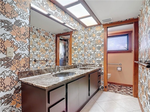 bathroom featuring tile patterned flooring, vanity, and toilet