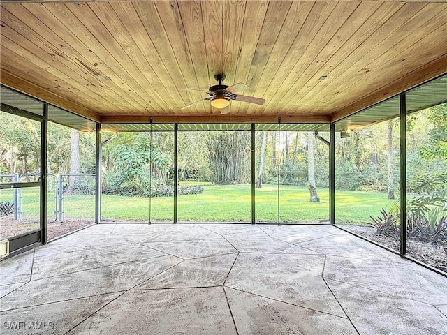 unfurnished sunroom featuring ceiling fan, a healthy amount of sunlight, and wood ceiling