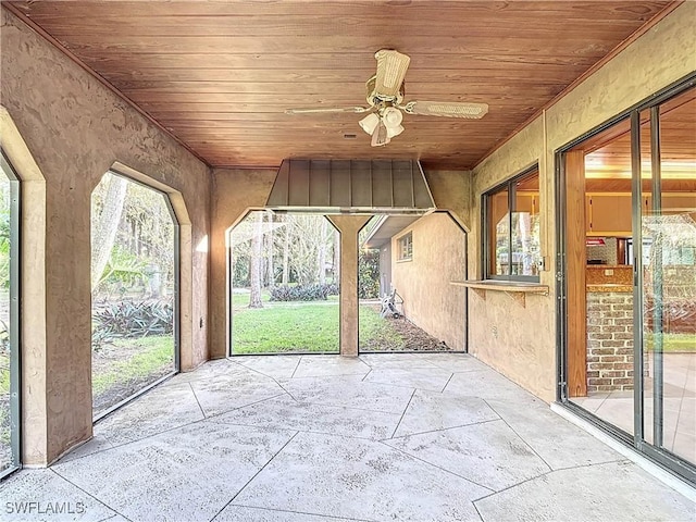 unfurnished sunroom featuring ceiling fan and wood ceiling