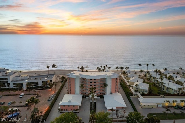 aerial view at dusk featuring a water view