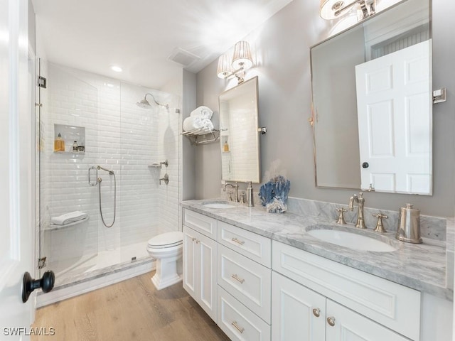 bathroom featuring hardwood / wood-style flooring, vanity, toilet, and walk in shower