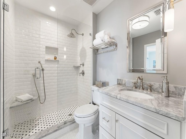 bathroom with toilet, a shower with shower door, and vanity