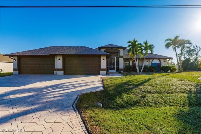 view of front of property with a garage and a front lawn