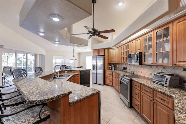 kitchen with a spacious island, sink, a breakfast bar area, pendant lighting, and stainless steel appliances