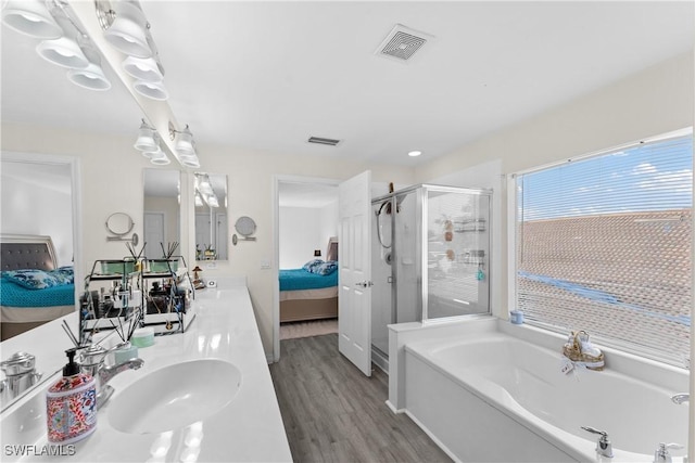 bathroom with wood-type flooring, vanity, and independent shower and bath