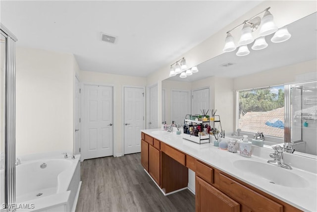 bathroom with a bathtub, vanity, and wood-type flooring