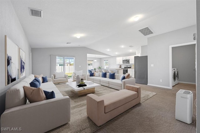 living room featuring washer and dryer, light colored carpet, and lofted ceiling