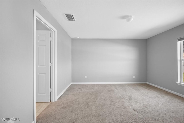 spare room featuring light colored carpet