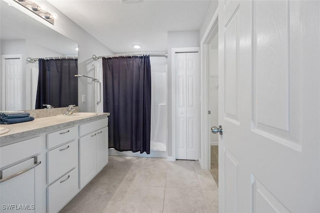 bathroom featuring tile patterned floors, vanity, and walk in shower