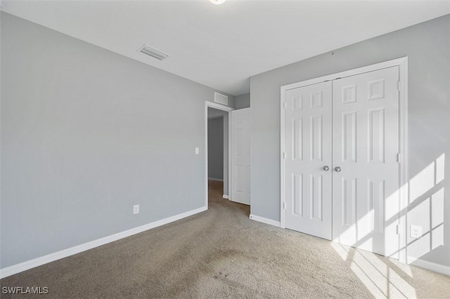 unfurnished bedroom featuring carpet flooring and a closet