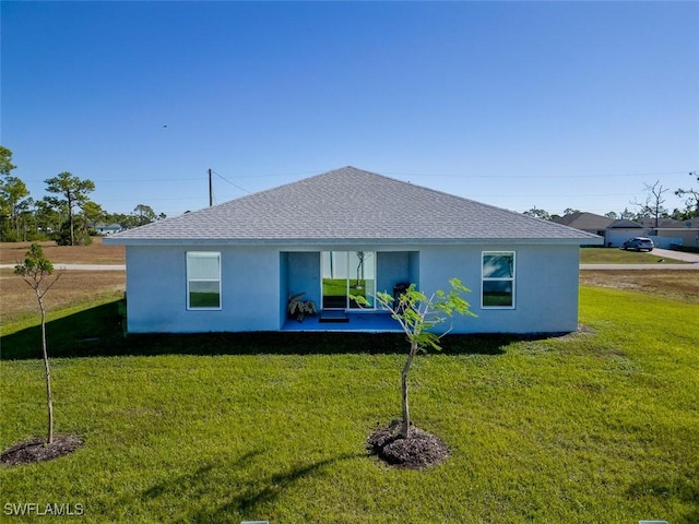 back of house with a patio area and a lawn