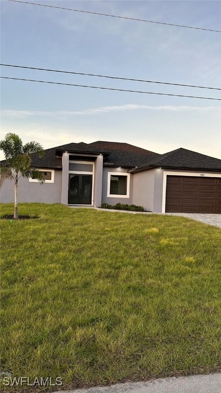 view of front of property with a garage and a front lawn