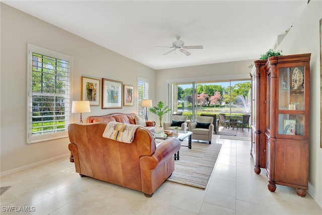 tiled living room with a wealth of natural light and ceiling fan