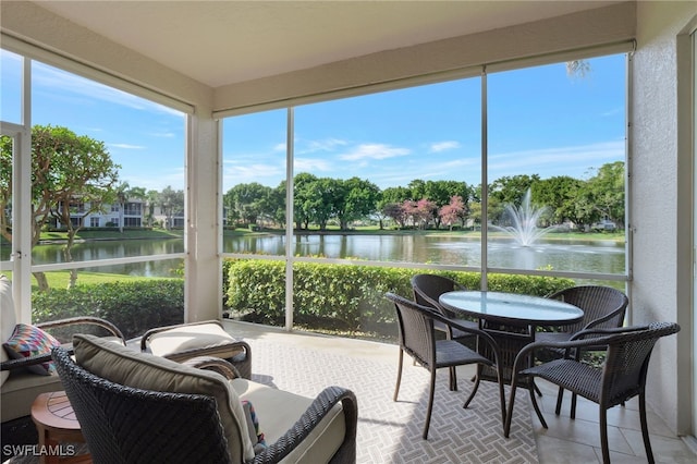 sunroom / solarium featuring a water view